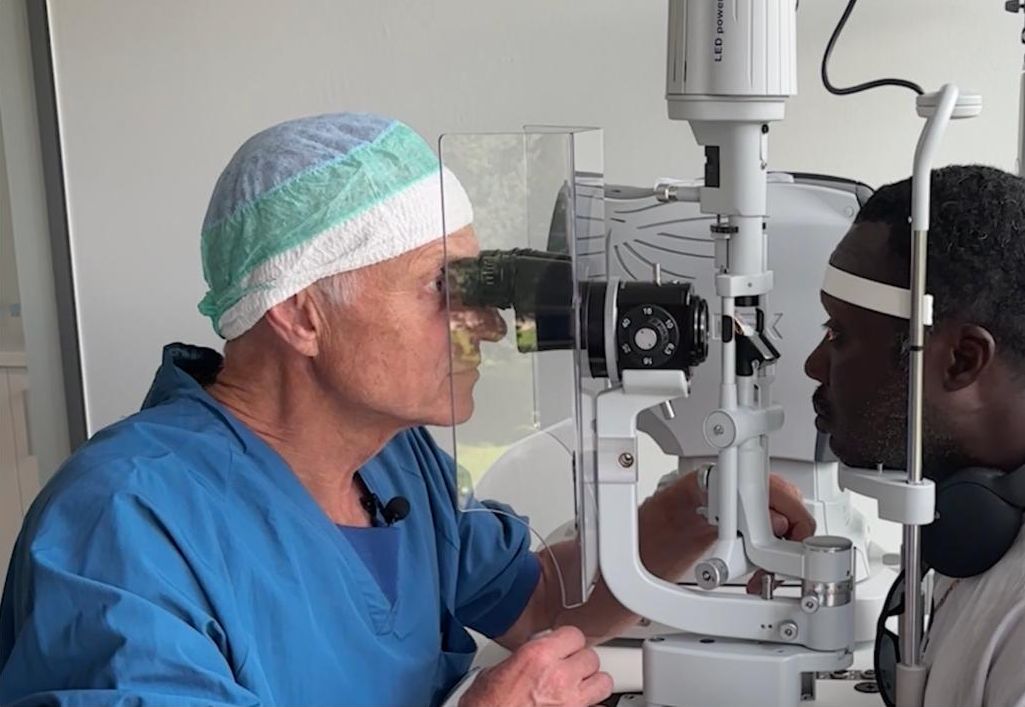 Eye surgeon examining a patient at a slit lamp
